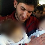 Πατέρας κρατά στην αγκαλιά του τα δίδυμα νεκρά παιδιά του
