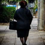 Ηλικιωμένη γυναίκα περπατά στο πεζοδρόμιο