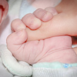 Μωρό πιάνει με το χέρι του το δάκτυλο ενός ενήλικα