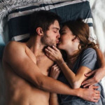 Αγκαλιασμένο ζευγάρι στο κρεβάτι φιλιέται
