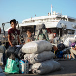 Προσφυγόπουλο περιμένει να επιβιβαστεί στο πλοίο, στη Μυτιλήνη