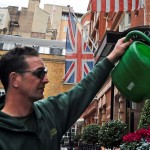 άνδρας ποτίζει φυτά στο Λονδίνο