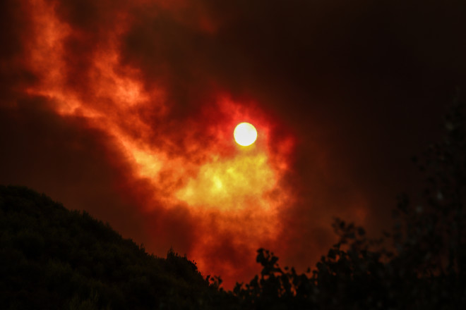 Oι φλόγες και ο καπνός κάλυψαν τον ήλιο- φωτογραφία Eurokinissi