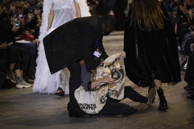 Άνδρες της ασφάλειας ακινητοποίησαν την ακτιβίστρια που εισέβαλε σε επίδειξη μόδας- φωτογραφία ΑΡ