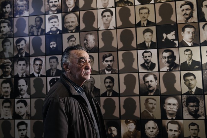Ο Γιώργος Δημόπουλος, επιζών της σφαγής των Καλαβρύτων, το 2015 φωτογραφίστηκε δίπλα στο πορτρέτο του εκτελεσθέντος πατέρα του (τέταρτη σειρά, πέμπτη στήλη) (φωτ. AP)