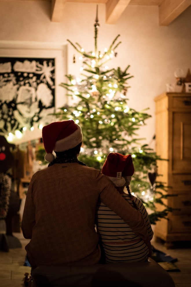 Πατέρας και κόρη κοιτούν το στολισμένο χριστουγεννιάτικο δέντρο