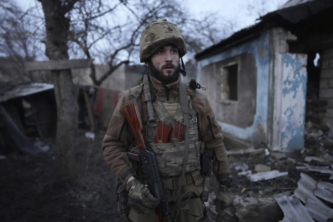 Ένας Ουκρανός στρατιώτης στέκεται μπροστά από ένα ισοπεδωμένο σπίτι/AP
