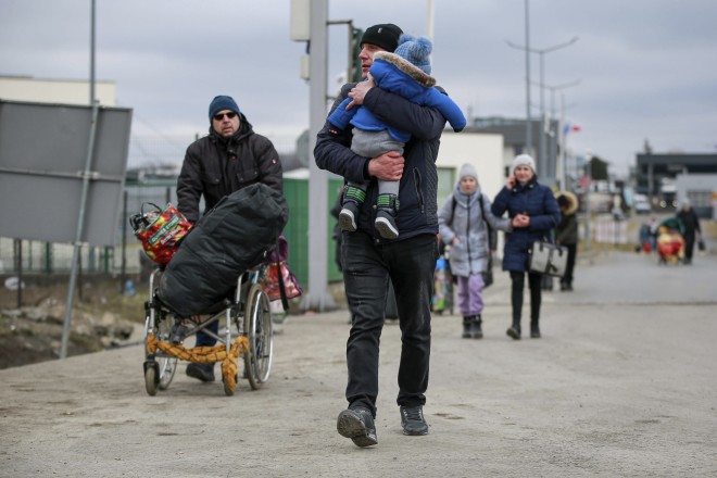 άνδρες πρόσφυγες οδηγούν τις οικογένειές τους στα σύνορα με την Πολωνία