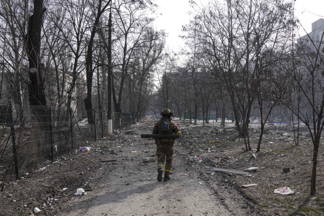 Ένας Ουκρανός στρατιώτης περπατά κοντά στη θέση που φρουρούσε στη Μαριούπολη της Ουκρανίας, Σάββατο 12 Μαρτίου 2022. (AP Photo/Evgeniy Maloletka)