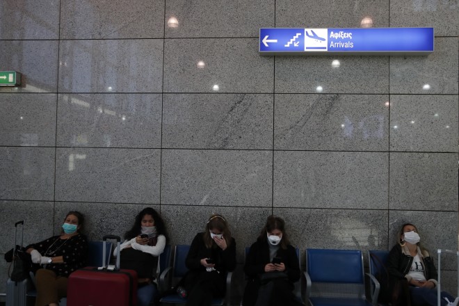 Επιβάτες με μάσκες περιμένουν στο Διεθνές Αεροδρόμιο Ελευθέριος Βενιζέλος στην Αθήνα την Τρίτη 17 Μαρτίου 2020. Οι ελληνικές αρχές ανακοίνωσαν ότι όποιος εισέρχεται στη χώρα από το εξωτερικό θα υπόκειται σε υποχρεωτική αυτοκαραντίνα για 14 ημέρες. (AP Photo/Θανάσης Σταυράκης)