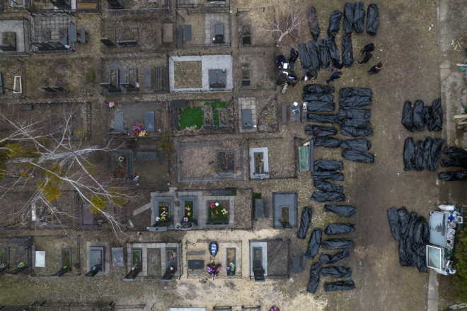 Οι αστυνομικοί εργάζονται για τον εντοπισμό αμάχων που σκοτώθηκαν κατά τη διάρκεια της ρωσικής κατοχής στη Bucha της Ουκρανίας, στα περίχωρα του Κιέβου, πριν στείλουν τα πτώματα στο νεκροτομείο, Τετάρτη 6 Απριλίου 2022. (AP Photo/Rodrigo Abd)