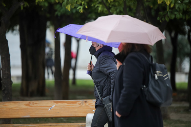 Κόσμος κρατά ομπρέλες λόγω βροχής στο κέντρο της Αθήνας