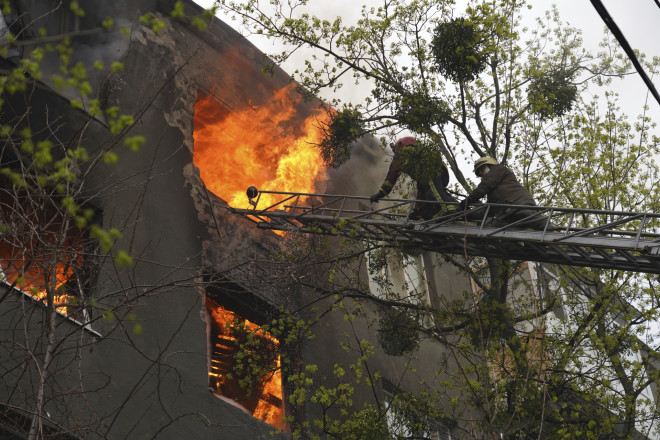 Οι πυροσβέστες σβήνουν τις φωτιές σε κτίρια που προκύπτουν από τις επιθέσεις 