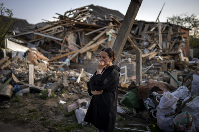 Μία γυναίκα κλαίει κοιτώντας το βομβαρδισμένο σπίτι της στο Κίεβο 