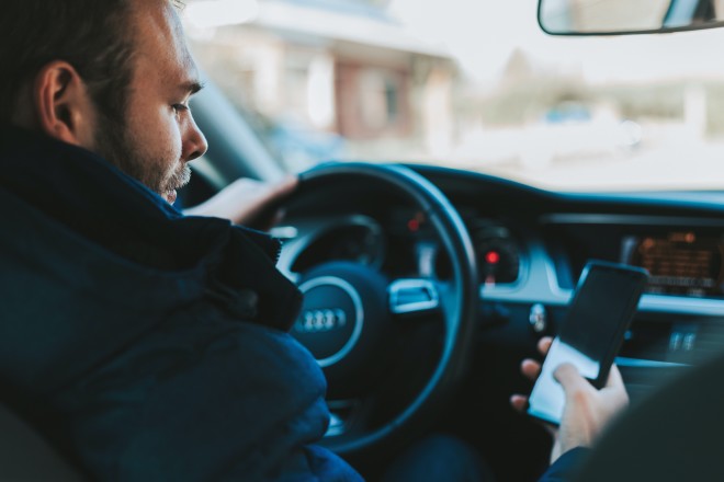 οδηγός αυτοκινήτου στέλνει γραπτό μήνυμα με το έξυπνο κινητό του