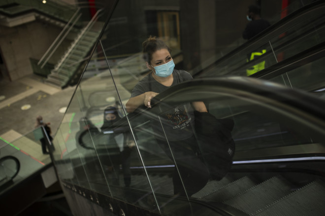 Άνθρωποι, φορούν μάσκες για την προστασία από την εξάπλωση του κορωνοϊού (AP Photo/Francisco Seco)