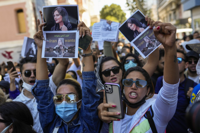 Γυναίκες κρατούν φωτογραφίεςτης Ιρανής Mahsa Amini καθώς φωνάζουν συνθήματα κατά τη διάρκεια διαμαρτυρίας έξω από το γενικό προξενείο του Ιράν στην Κωνσταντινούπολη,(AP Photo/Francisco Seco)