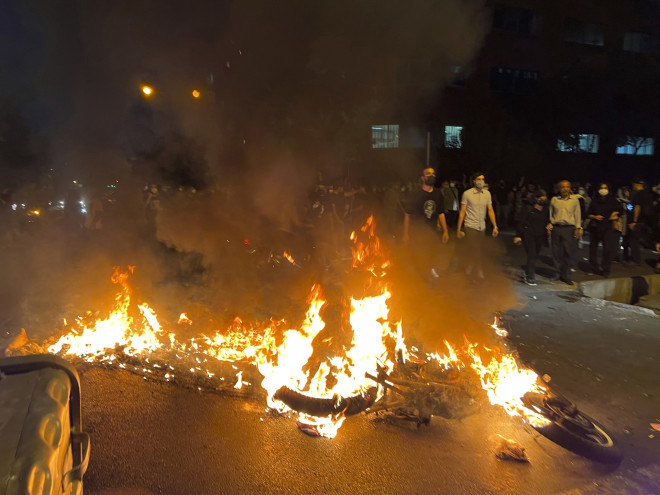 Mια αστυνομική μοτοσικλέτα καίγεται κατά τη διάρκεια διαμαρτυρίας για τον θάνατο της Μαχσά Αμινί στο κέντρο της Τεχεράνης, στο Ιράν. (Φωτογραφία AP)