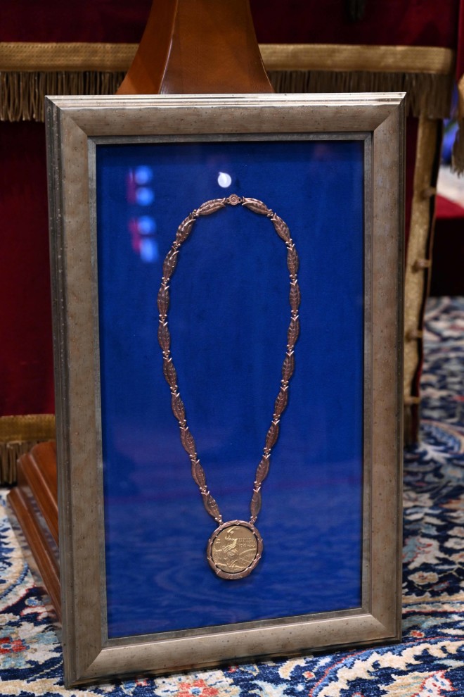 Μπροστά από το φέρετρο είναι τοποθετημένα τα παράσημα και το ολυμπιακό μετάλλιο του τέως βασιλιά