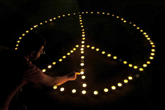 To σύμβολο της Ειρήνης σχηματισμένο με αναμμένα κεριά έξω από την αμερικανική πρεσβεία στην Κύπρο/ AP Photo- Petros Karadjias