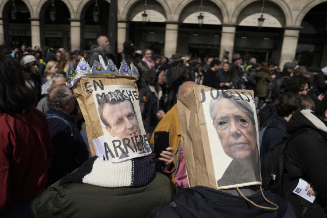 Διαδηλωτές κατά του συνταξιοδοτικού φόρεσαν μάσκες με τα πρόσωπα του Μακρόν και της Μπορν/ AP Photo/Lewis Joly