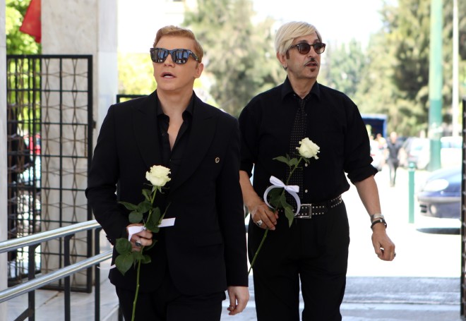 Ο Τάκης Ζαχαράτος κι ο Δημήτρης Παπάζογλου με ένα λευκό τριαντάφυλλο στην κηδεία της Νόνικας Γαληνέα