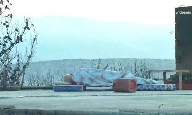 Άνδρας κοιμάται στην ταράτσα του καμένου σπιτιού του στη Μάνδρα