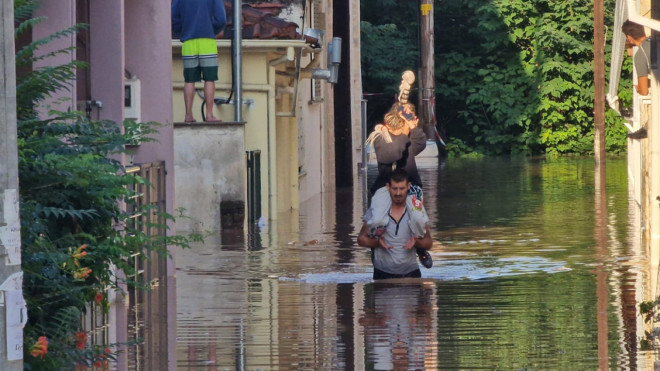 Γονείς στη Λάρισα κουβαλούν τα παιδιά τους στους ώμους για να τα απομακρύνουν από τις πλημμυρισμένες περιοχές