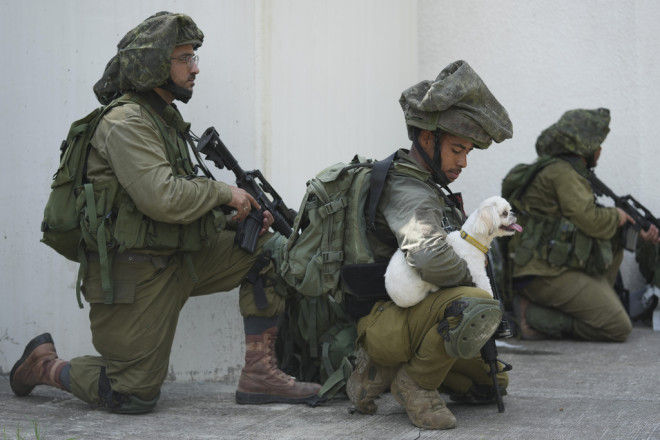 Στρατιώτες του Ισραήλ με σκύλο που βρήκαν στο κιμπούτς Κφα Αζάρ μετά τη σφαγή    