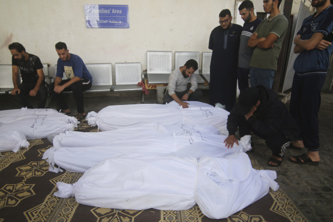 Παλαιστίνιοι γύρω από τα πτώματα συγγενών τους που σκοτώθηκαν από αεροπορικά πλήγματα του Ισραήλ/ AP Photo/Hatem Ali