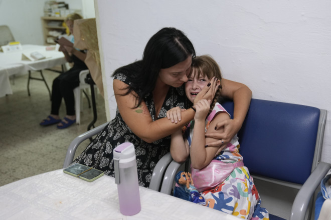 Ένα τρομαγμένο κοριτσάκι στην αγκαλιά της μαμάς του σε καταφύγιο της πόλης Άσκελον/  (AP Photo/Ohad Zwigenberg)