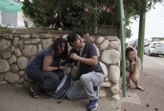 Ισραηλινοί καλύπτονται τη στιγμή εκτόξευσης ρουκέτας στη Λωρίδα της Γάζας/ (AP Photo/Leo Correa)