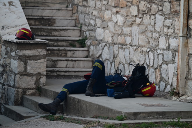 Πυροσβέστης ξαπλώνει λίγο για να ξεκουραστεί πριν ριχτεί και πάλι στη μάχη με τις φλόγες στη ΒΑ Αττική - Eurokinissi