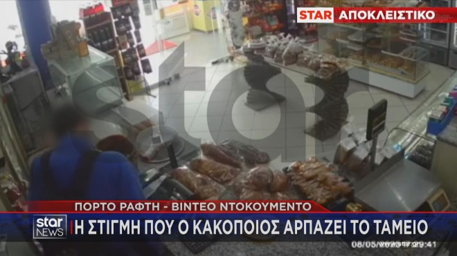 Ο ληστής ενώ αρπάζει τα χρήματα από το ταμείο  