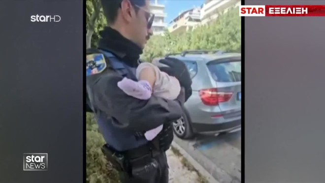 Άλιμος: Αστυνομικός κρατά το μωρό που βρέθηκε σε κάδο