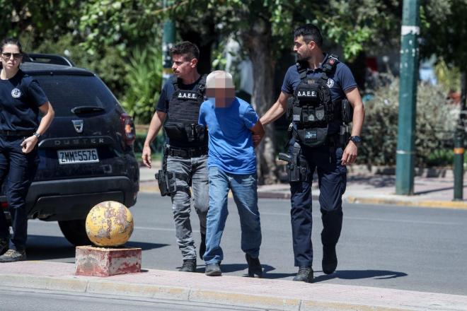 Ο κατηγορούμενος για τον εμπρησμό στην Παιανία ενώ οδηγείται ενώπιον των  δικαστικών αρχών  