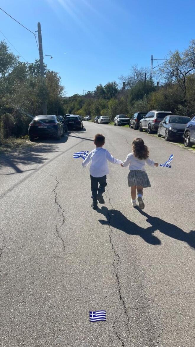 Αχιλλέας και Ακυλίνα κρατώντας ελληνικά σημαιάκια
