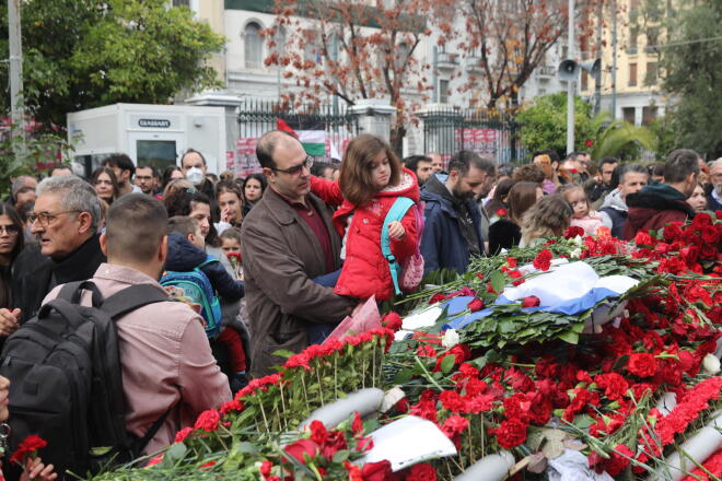 Μπαμπάς και κόρη αφήνουν λουλούδι στο μνημείο για το Πολυτεχνείο