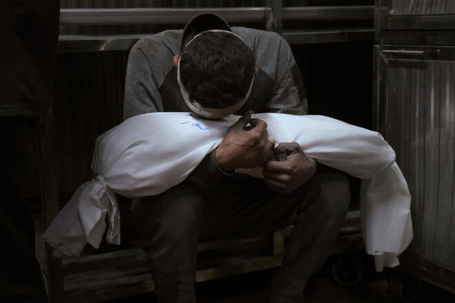 Ο Χοσάμ Αζάμ κρατά το σώμα του παιδιού του, Άμιρ, ο οποίος σκοτώθηκε σε ισραηλινή αεροπορική επιδρομή στη Γάζα, στο Νοσοκομείο Σίφα στη Γάζα Σίτι, στις 15 Ιουλίου 2025. (AP Photo/Jehad Alshrafi, File)