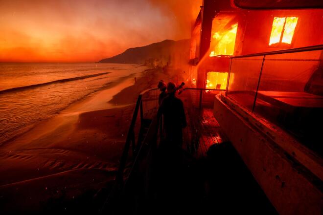 Firefighters battle flames engulfing a beachfront property in Malibu, Calif., during the Palisades Fire on Jan. 8, 2025. (AP Photo/Etienne Laurent, File)