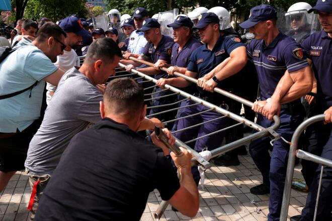Διαδηλωτές προσπαθούν να απομακρύνουν ένα οδόφραγμα καθώς η αστυνομία το κρατάει κατά τη διάρκεια συγκρούσεων στα Τίρανα της Αλβανίας AP Photo/Hameraldi Agolli